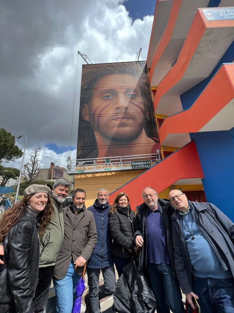 Il mare di Napoli bagna gli occhi di Mario Paciolla nel murales di Jorit
